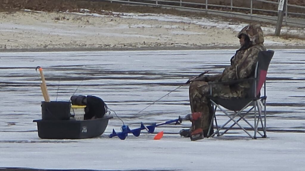 Image of people ice fishing (2) - for the Ultimate Guide to Frozen Laurel Lake in the Winter - Pine Grove Frunace State Park in Michaux State Forest - Awesome Carlisle! - Carlisle PA Guides and News - shows the drill they use to drill the hole