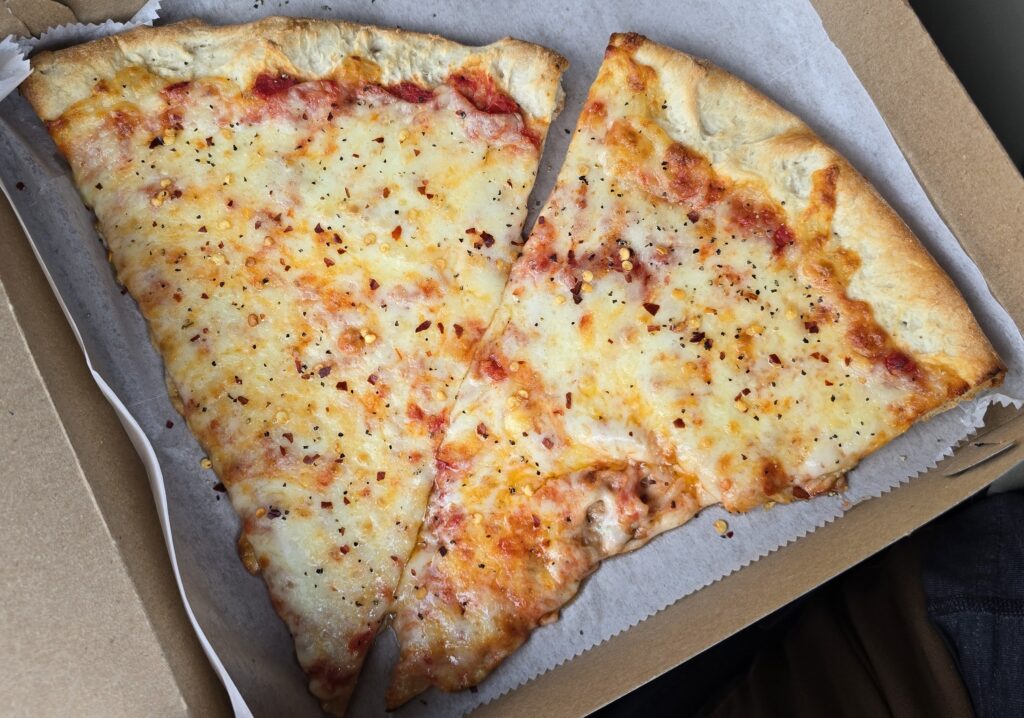 top down picture of 2 slices of pizza at Miseno II Pizzeria & Italian in Carlisle, PA with red pepper flakes and black pepper on them - best slice of pizza in Carlisle Pennsylvania - awesome carlisle - best of carlisle, pa