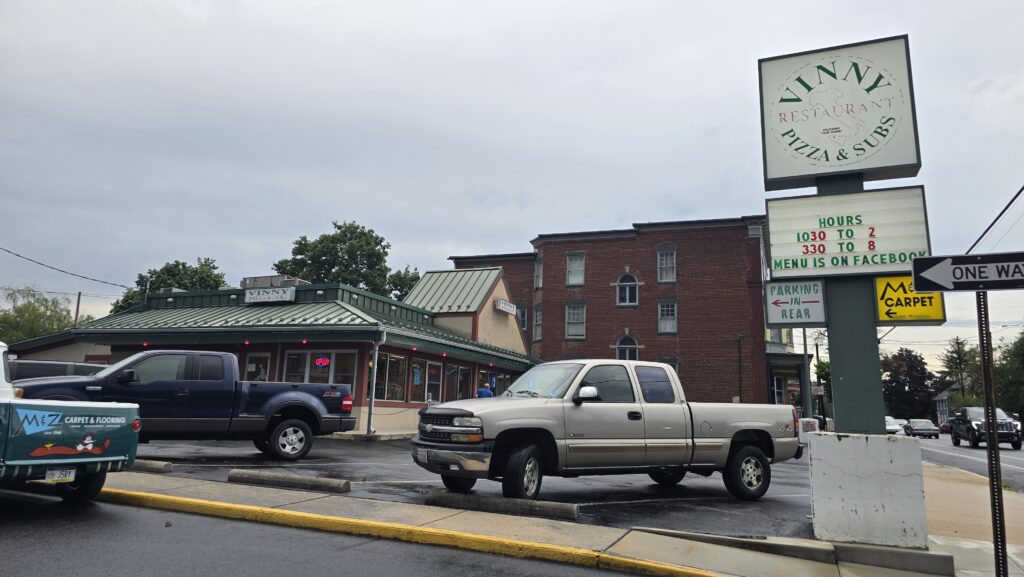 View of parking lot and building including sign of Vinny Restaurant Pizza and Subs in Carlisle, PA taken from intersection at cross street - Carlisle, PA Pizza Reviews - Awesome Carlisle!