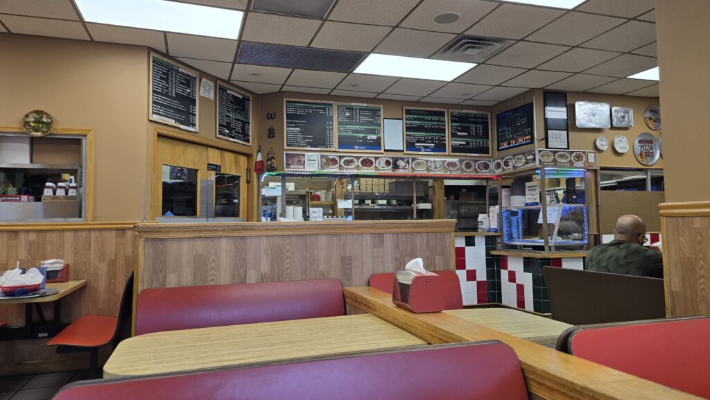 From Dining Room table against front window wall looking at the ordering counter with menu above the counter at Vinny Restaurant Pizza and Subs in Carlisle, PA taken from a table against the front window wall - Carlisle, PA Pizza Reviews - Awesome Carlisle!